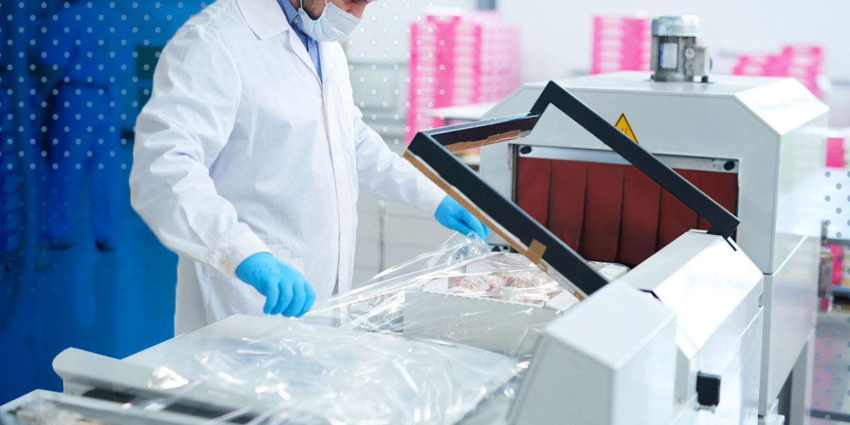 Line technician operating a device applying protective packaging to food items